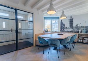 a dining room with a table and blue chairs at Watertoren Vlissingen in Vlissingen