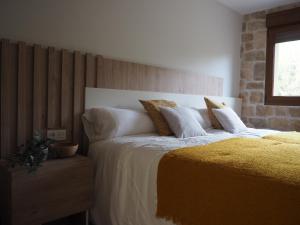een slaapkamer met een groot bed met witte lakens en kussens bij Casa Rural Del Valle Estrecho  +13 foto's