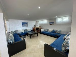 Maison Bord de Mer Skhirate في الصخيرات‎: غرفة معيشة مع أرائك زرقاء وطاولة +19 صورة