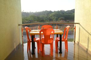 - Balcón con mesa y 4 sillas en Lake Breeze Resort, en Alibaug