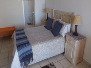 a bedroom with a large bed with blue pillows at Villa Siesta Flat No 5 in Margate