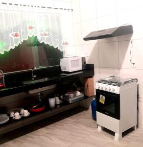 una cucina con fornelli e microonde di Ilha do Sol a Arraial d'Ajuda