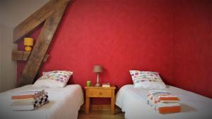 two twin beds in a room with red walls at "Chambre 2", Ferme de la Volière in Gidy