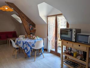 a dining room with a table with chairs and a microwave at "Chambre 2", Ferme de la Volière in Gidy
