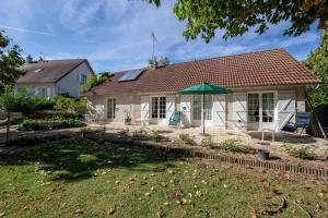 a house with a green umbrella in the yard at "Chambre Lorris", Ferme de la Borde in Saint-Benoît-sur-Loire