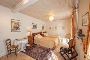 a bedroom with a bed and a table and chairs at "Chambre Lorris", Ferme de la Borde in Saint-Benoît-sur-Loire