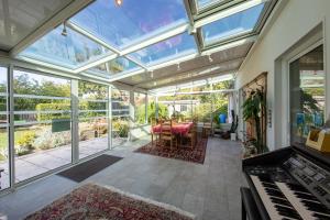 een binnenserre met een tafel en een piano bij "Chambre Lorris", Ferme de la Borde in Saint-Benoît-sur-Loire
