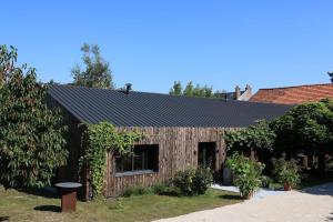 a wooden house with a black roof at Chambre "Argentine", Le Clos des Poulies in La Ferté-Saint-Aubin