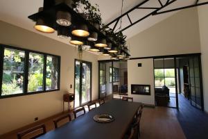 a dining room with a table and some windows at Chambre "Argentine", Le Clos des Poulies in La Ferté-Saint-Aubin