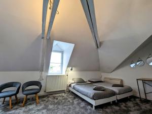 een slaapkamer met twee bedden en twee stoelen bij Château Raoul in Châteauroux