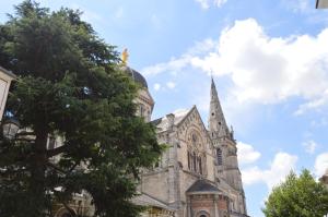 een kerk met een toren en een boom bij Château Raoul in Châteauroux