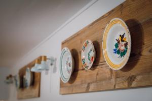 a row of plates on a wooden wall at Pensiunea Nossa Panzió in Corunca