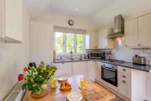 The Bolthole في Biddenden: مطبخ بخزائن بيضاء وطاولة خشبية