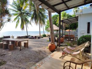 Baan Toom Village and Resort في تشانتابوري: فناء مع طاولة وكراسي على الشاطئ
