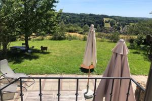 two patio umbrellas on a balcony with a view of a field at La bergerie - Point de vue sur la Creuse in Ceaulmont