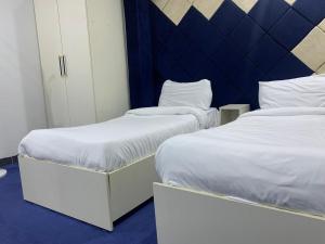 Dos camas una al lado de la otra en una habitación. en موتيلى دانزه اربيل 3, en Erbil