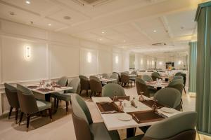 a restaurant with tables and chairs in a room at Arth Boutique Hotel in Kota