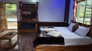 a bedroom with a bed with pillows on it at Greenary homestay in Ooty