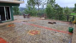 a patio of a house with a table and chairs at Greenary homestay in Ooty +4 photos