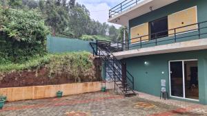 a building with a staircase on the side of it at Greenary homestay in Ooty