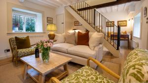 een woonkamer met een bank en een tafel bij Oak Cottage in Swerford