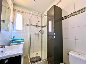 un baño con ducha y lavabo en Brise Marine - Appartement 2 chambres avec balcon, vue mer & parking privé à 30 m de la plage, en Palavas-les-Flots 16 fotos más