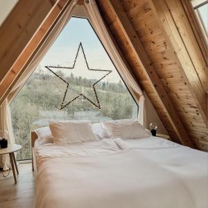 a bed in a room with a large window at Zebi vendégház in Zebegény
