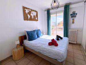 Un dormitorio con una cama con dos animales de peluche encima. en Brise Marine - Appartement 2 chambres avec balcon, vue mer & parking privé à 30 m de la plage, en Palavas-les-Flots