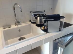 a kitchen counter with a sink and a appliance at Denis & Virginie - château à pied - parking gratuit in Versailles +24 photos