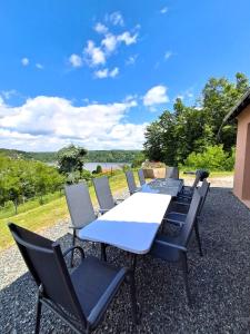 a table and chairs on a gravel patio at Les hauts du lac - 500 m du lac - Vu sur le lac in Éguzon-Chantôme