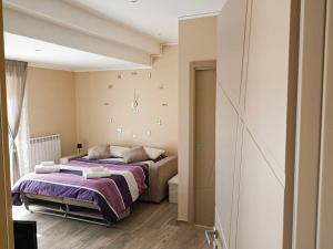 a bedroom with a large bed with purple sheets at Belvedere Vallata Affitti Brevi in Vallata