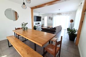 a living room with a wooden table and a couch at Les hauts du lac - 500 m du lac - Vu sur le lac in Éguzon-Chantôme