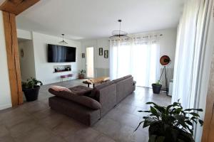 a living room with a couch and a tv at Les hauts du lac - 500 m du lac - Vu sur le lac in Éguzon-Chantôme