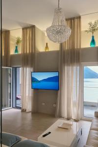 un soggiorno con TV e una grande finestra di Villa Morion a Donji Morinj Altre 22 foto