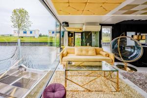 Wangerland Resort في انجرلاند: غرفة معيشة مع أريكة وجدار زجاجي