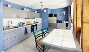 een keuken met blauwe muren en een tafel en stoelen bij Ty ravissant - Les Gîtes de la Côte d'Amour in Le Croisic