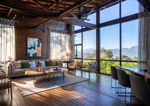 ein Wohnzimmer mit vielen Fenstern in der Unterkunft LohonoStays Villa Amani 8B in Coonoor