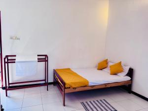 a bed in a room with yellow pillows on it at Harshi Guest House in Matara +6 photos