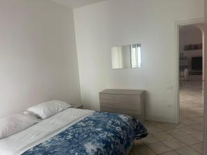een slaapkamer met een bed, een ladekast en een spiegel bij Emy House in Azzano San Paolo