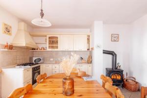 a kitchen with a wooden table with chairs and a stove at The Dolomites Lodge in San Pietro di Cadore +14 photos