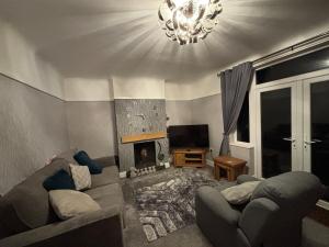 a living room with a couch and a fireplace at Entire House, Parking, Facilities, sleeps up to 6, suitable for contractors, families or NHS in Liverpool