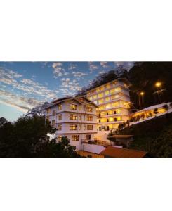 a large white building with a mountain in the background at DreamVilla Retreat Apartment Pelling in Pelling