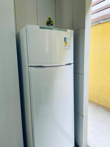 - un réfrigérateur blanc installé dans une cuisine à côté d'un mur dans l'établissement Lofts Inverno Centro Histórico, à Parati