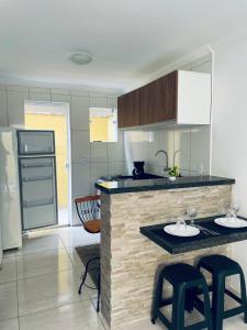 une cuisine avec deux tabourets de bar et un comptoir dans l'établissement Lofts Inverno Centro Histórico, à Parati