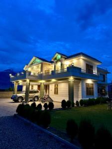 Una casa grande con un camión estacionado enfrente. en Crown Resort, en Skardu