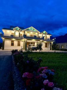 una gran casa blanca con un coche aparcado delante de ella en Crown Resort, en Skardu