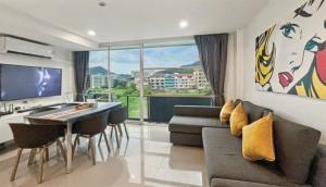 a living room with a couch and a table and a television at Kris - Modern Spacious 2 Bedrooms Condo with Pool in Patong Beach