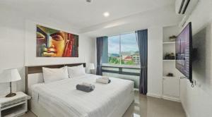 a bedroom with a large white bed and a large window at Kris - Modern Spacious 2 Bedrooms Condo with Pool in Patong Beach