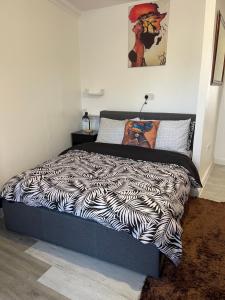 a bed in a bedroom with a zebra print sheets at Bowery Apartment - 2 Bedrooms 1st floor in Dagenham