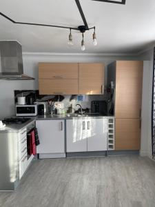 a kitchen with white appliances and wooden cabinets at Bowery Apartment - 2 Bedrooms 1st floor in Dagenham +6 photos